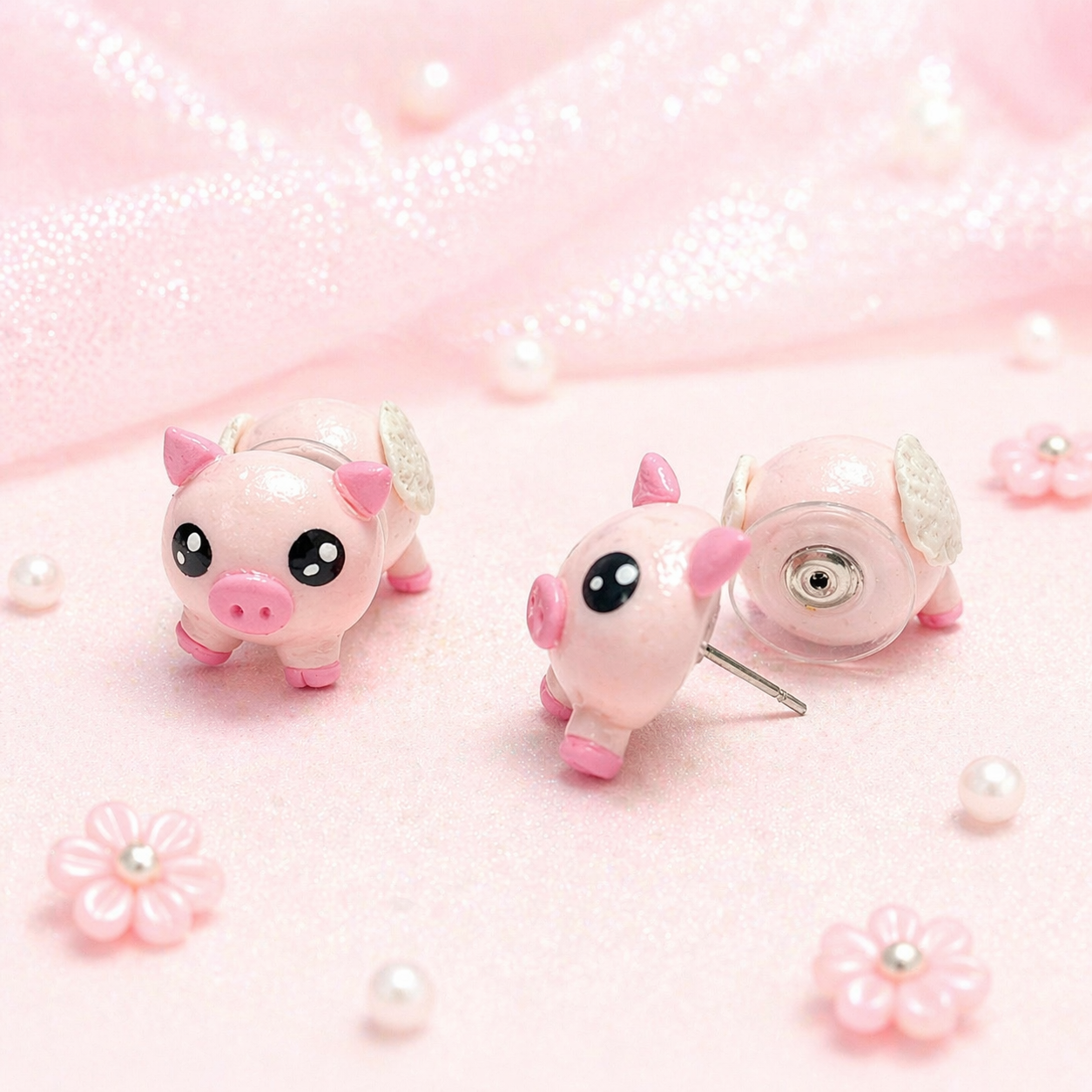 Detalle artesanal de aretes de cerdito angelito color rosa