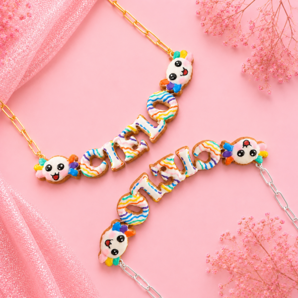 Collares personalizados de axolote kawaii con nombres decorados en colores, uno con cadena dorada y otro con cadena plateada.