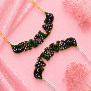 Collares personalizados de gatito negro enfadado kawaii con nombres decorados, uno con cadena dorada y otro con cadena plateada.