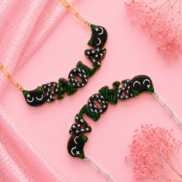 Collares personalizados de gatito negro enfadado kawaii con nombres decorados, uno con cadena dorada y otro con cadena plateada.