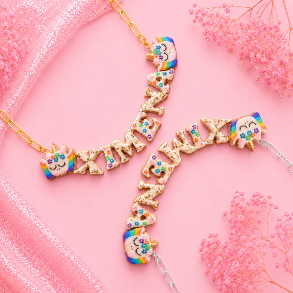 Collares personalizados de unicornio con alas kawaii con nombres decorados, uno con cadena dorada y otro con cadena plateada.